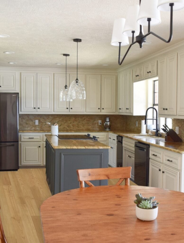 kitchen with beige painted off white cabinets, granite counters, travertine tile, photoshop wood floors.