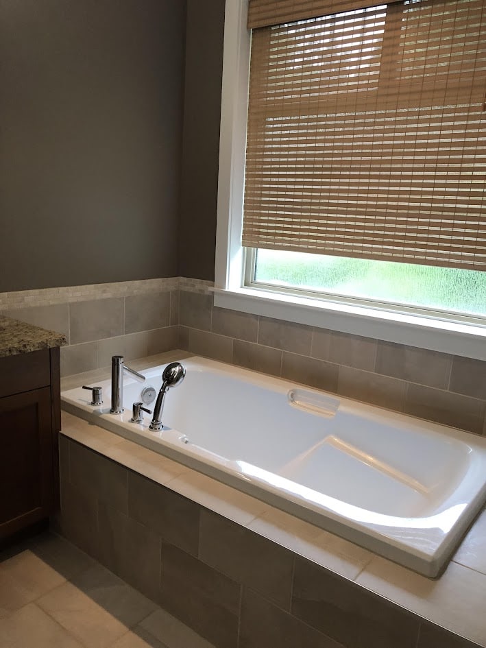 soaker tub with tile deck in pink beige 12x12, travertine, window
