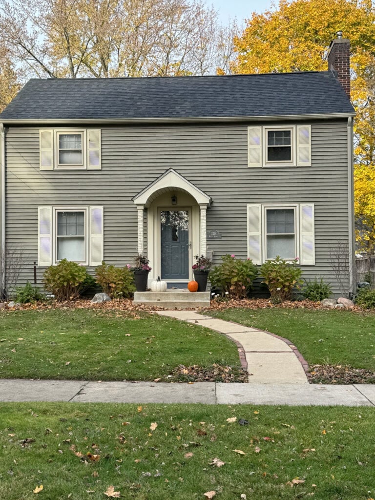 Arbor Blend green gray vinyl siding, almond trim, Benjamin Moore Anchor Gray front door, dark charcoal gray black asphalt fiberglass roof
