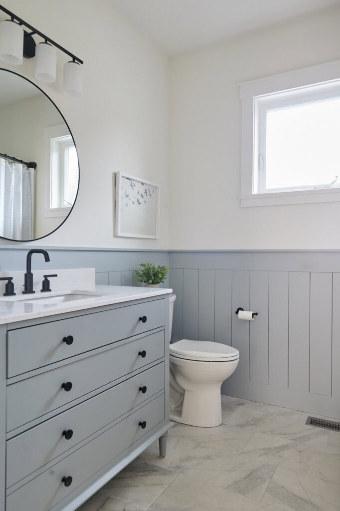 Bathroom, Sherwin Williams Network Gray, Benjamin Moore White Dove walls, granite vanity, black faucet, hardware, small bathroom vertical shiplap, marble look porcelain tile floor,