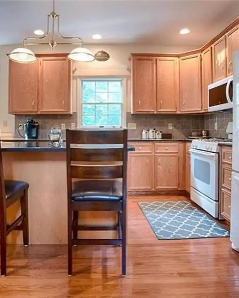 kitchen oak cabinets before, black granite, oak floor