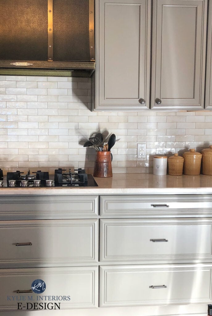 Painted kitchen cabinets, metal iron range hood, pewter cabinet hardware, warm graySherwin Williams Felted Wool, greige warm gray green cabinets, Taj Mahal quartzite. Kylie