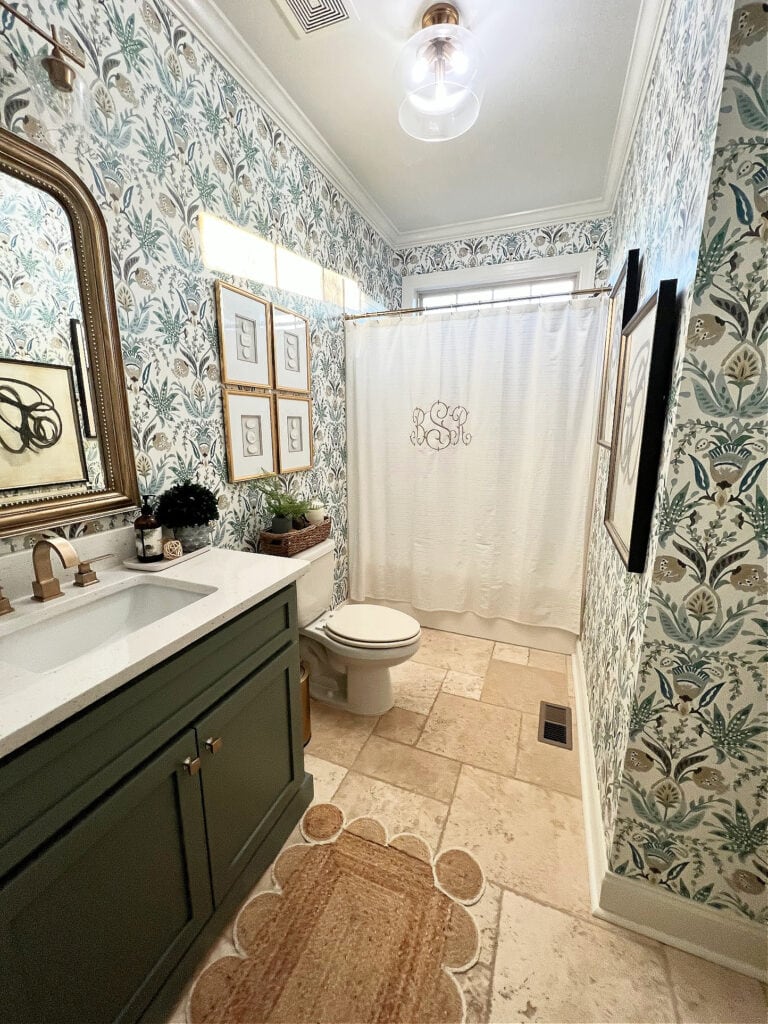 1990 bathroom with travertine tile floor, update ideas with dark green painted vanity, white quartz, floral pattern wallpaper, gold hardware (2)