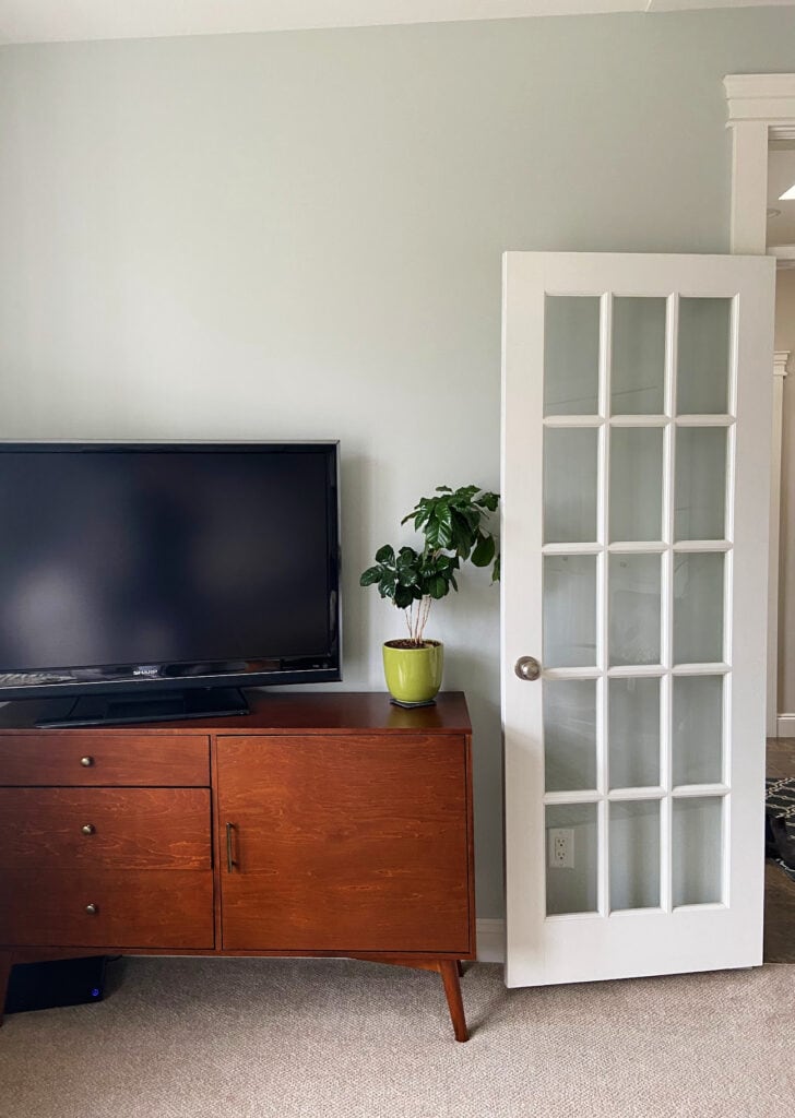 Benjamin Moore Gray Owl in den with light beige carpet, Cloud White trim