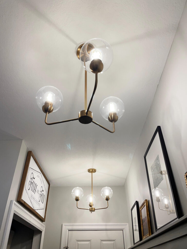 Benjamin Moore Gray Owl in laundry room with antique brass light fixtures and white textured ceiling