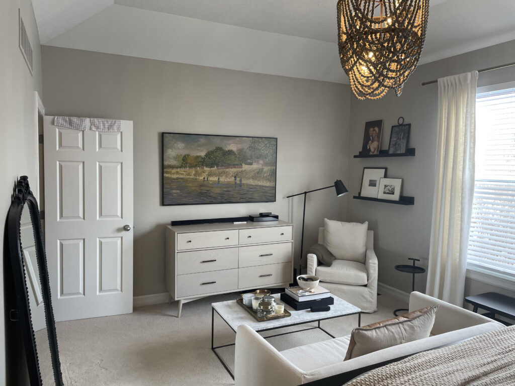 Benjamin Moore warm gray greige paint color, Revere Pewter, beige-taupe carpet, sofa at end of bed, neutral home decor and furnishings in bedroom. Kylie M client photo