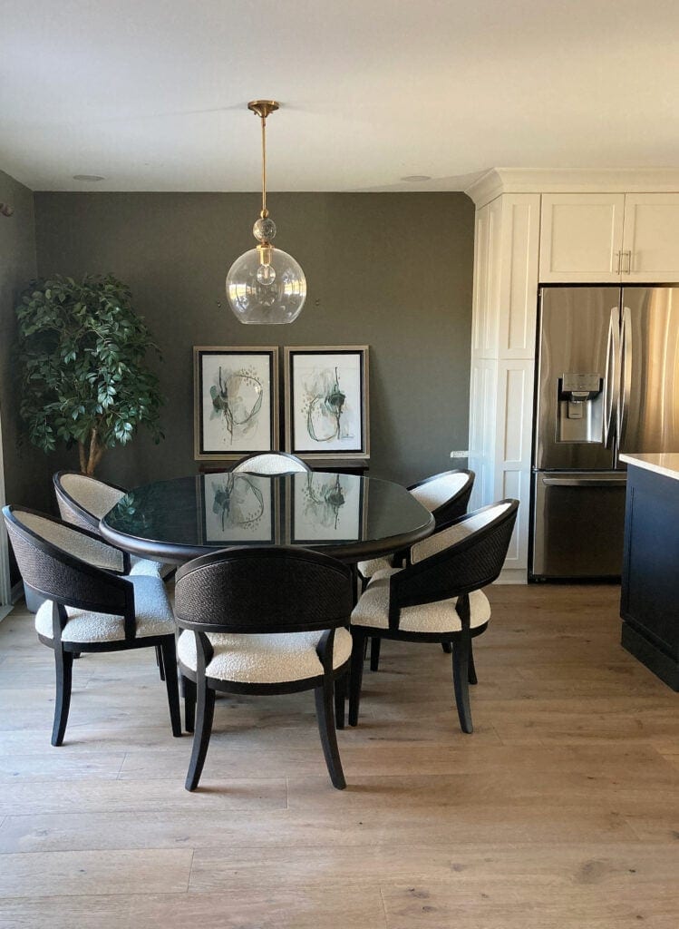 Gauntlet Gray accent wall in dining room with wood floor, Snowbound painted kitchen cabinets.