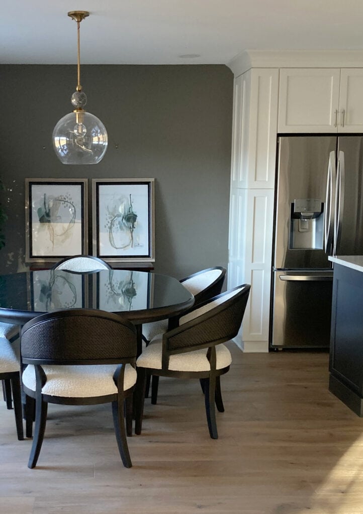 Kitchen cabinets painted Sherwin Williams Snowbound, wood flooring, Gauntlet Gray on the accent wall in dining area