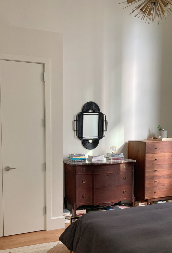 Loft style bedroom with high ceilings, wood flooring, Benjamin MOore China White, also known as Seapearl paint color on the walls, warm shade of off white