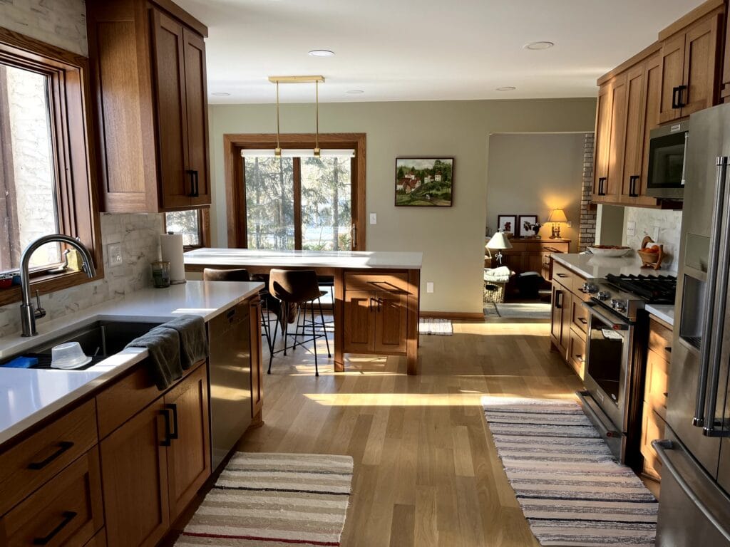 Red oak wood kitchen cabinet update, white quartz countertop, marble backsplash tile, island, wood trim, white oak floor.