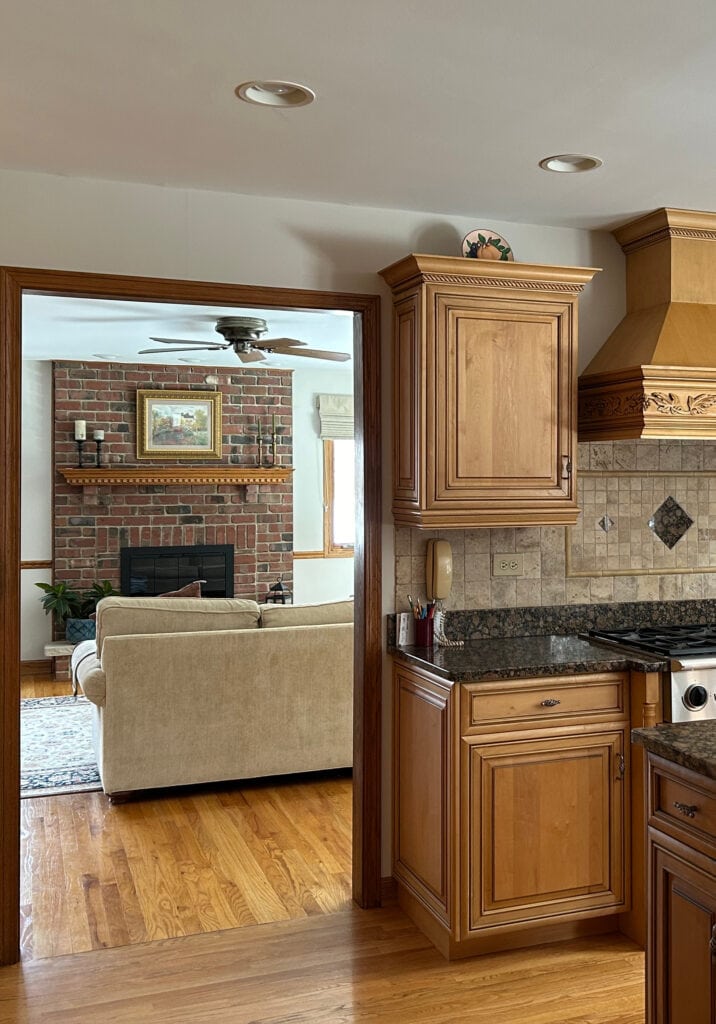 Tuscan style kitchen with wood maple cabinets, wood door trim, oak floor, Baltic Brown granite countertops, travertine tile backsplash, warm gray on walls