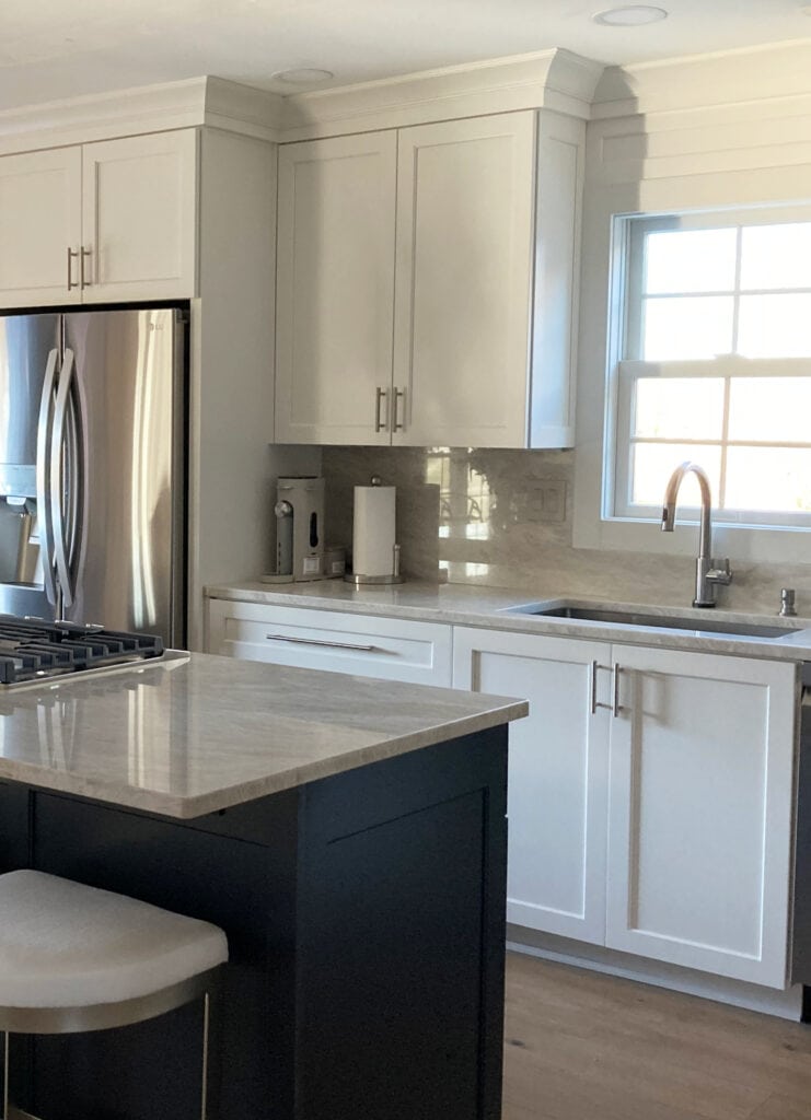 off-white soft white painted kitchen cabinets with Taj Mahal quartzite counters and countersplash slab, polished nickel hardware, stainless steel appliances. (2)