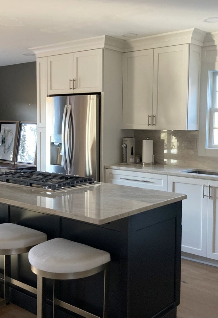 off-white soft white painted kitchen cabinets with Taj Mahal quartzite counters and countersplash slab, polished nickel hardware, stainless steel appliances. (3)