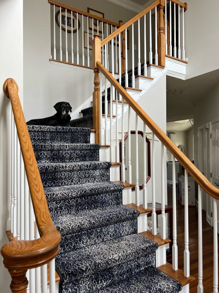 sHERWIN WILLIAMS AGREEABLE GRAY, GOLDEN OAK STAIR RAILING AND STAIRS WITH CARPET RUNNER, WHITE RISERS.