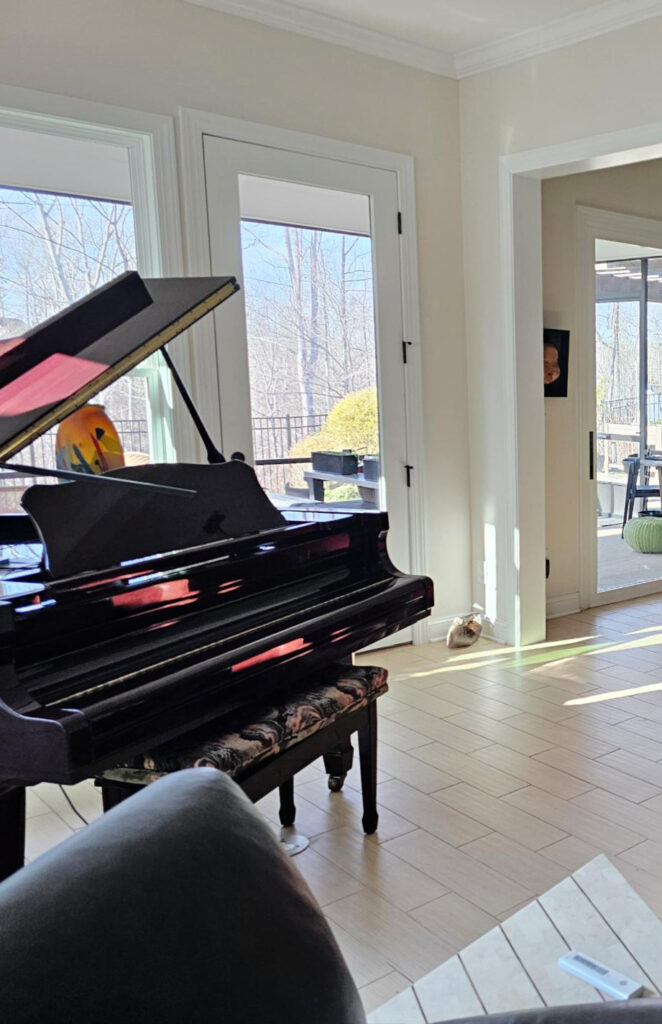 Baby grand piano, beige wood look tile floor, Benjamin Moore Maritime White warm off white paint color on walls, north west light