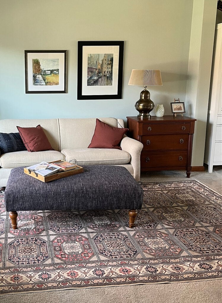 Beige taupe carpet in living room with area rug, Sherwin Williams Sea Salt paint color on walls, green-gray blue blend,