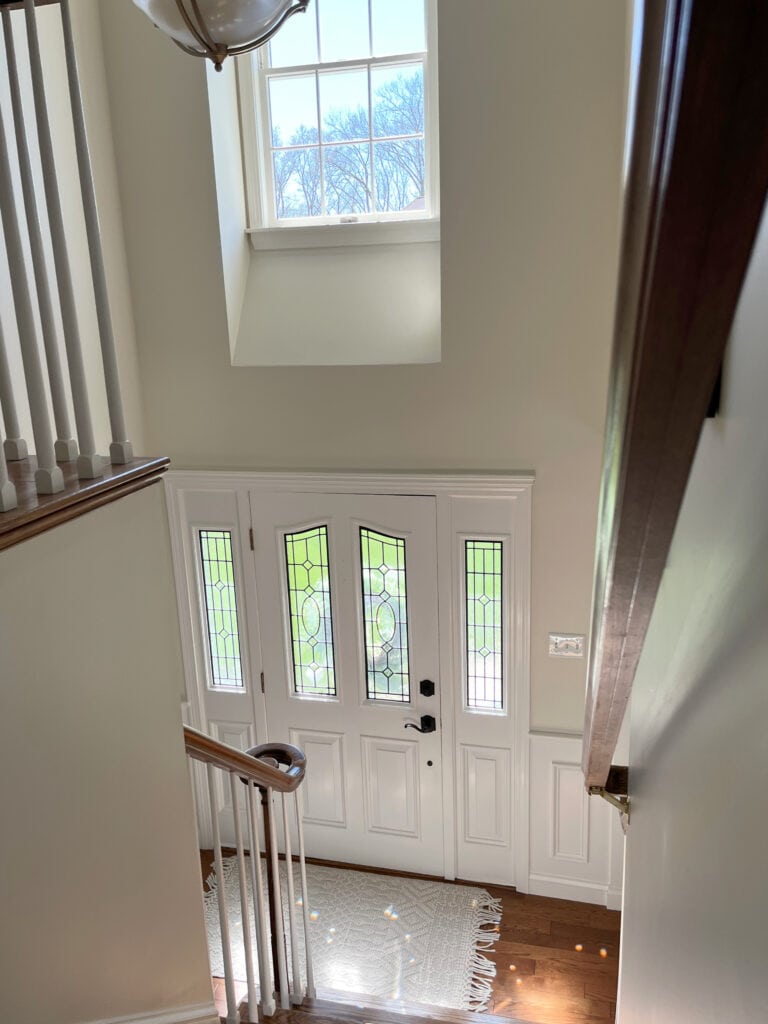 Benjamin MOore Ballet White walls in foyer and staircase, two storey, White Dove trim, door, wainscoting, oak floor