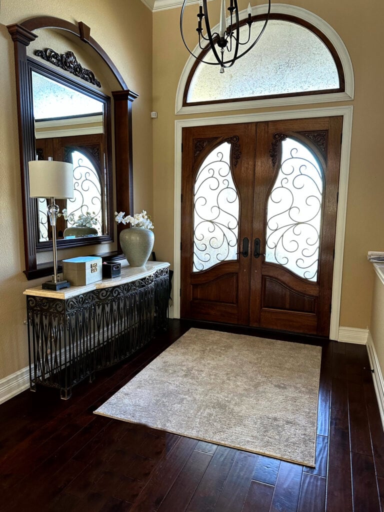 Entryway foyer, dark wood flooring, Greek Villa trim, wood door, Sherwin Williams Rowhouse Tan golden beige, yellowish paint color