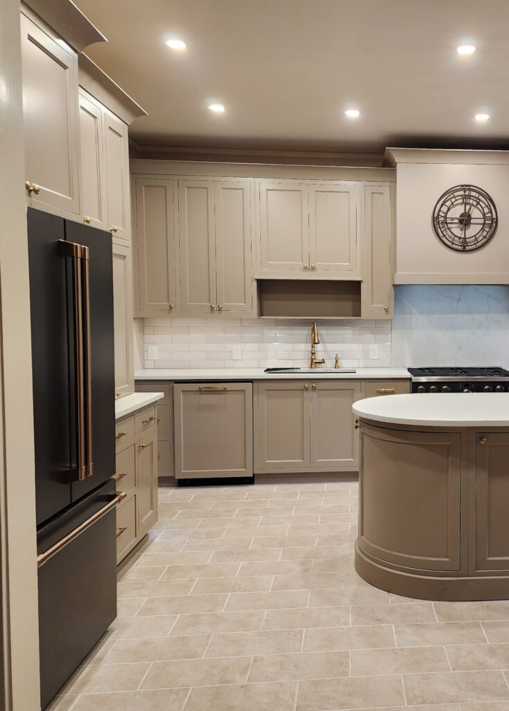 GE Cafe Matte Black appliances, brushed bronze hardware, beige tile floor, Sherwin Williams mushroom, greige taupe, painted kitchen wood cabinets, Cambria Ridgegate off-white quartz, gold hardware