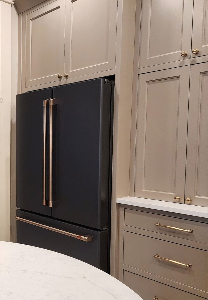 GE Cafe Matte black kitchen fridge, Sherwin Williams mushroom greige taupe painted wood cabinets, gold, brushed metal finish hardware