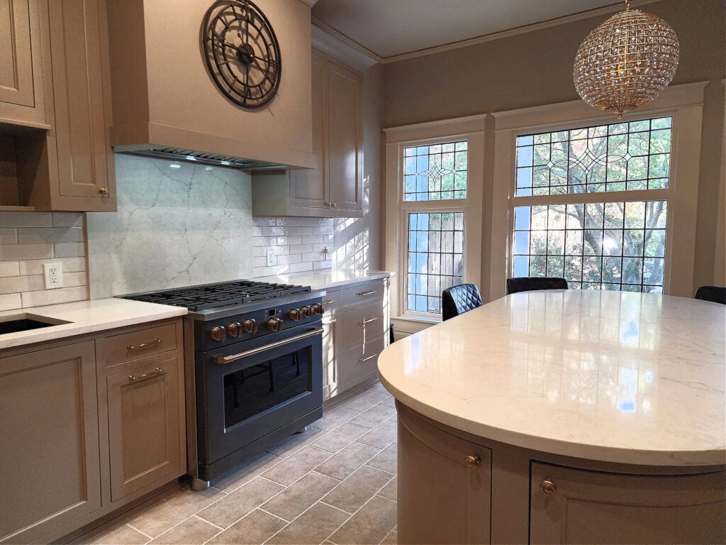 Ge Cafe Matte black kitchen range stove with greige taupe mushroom painted cabinets, quartzite counterrtop, subway tile, travertine look tile floor. Kylie M Interiors Edesign