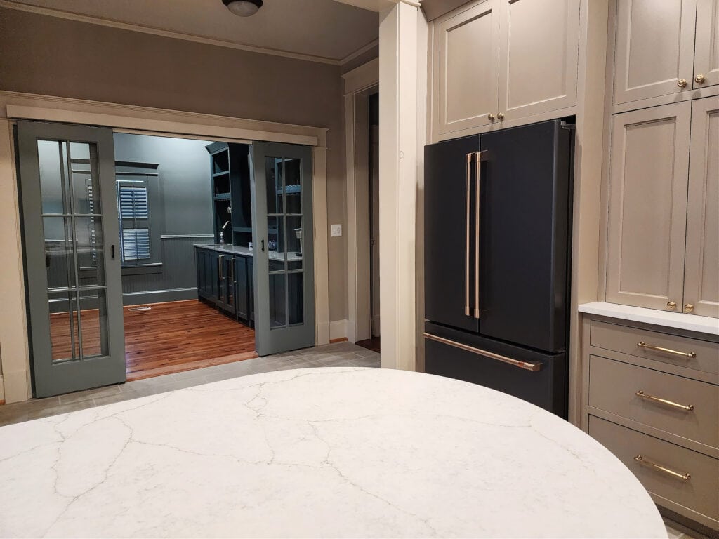 Mushroom, taupe greige painted kitchen wood cabinets, GE Cafe Mattte black fridge, off-white quartzite, french doors - Copy