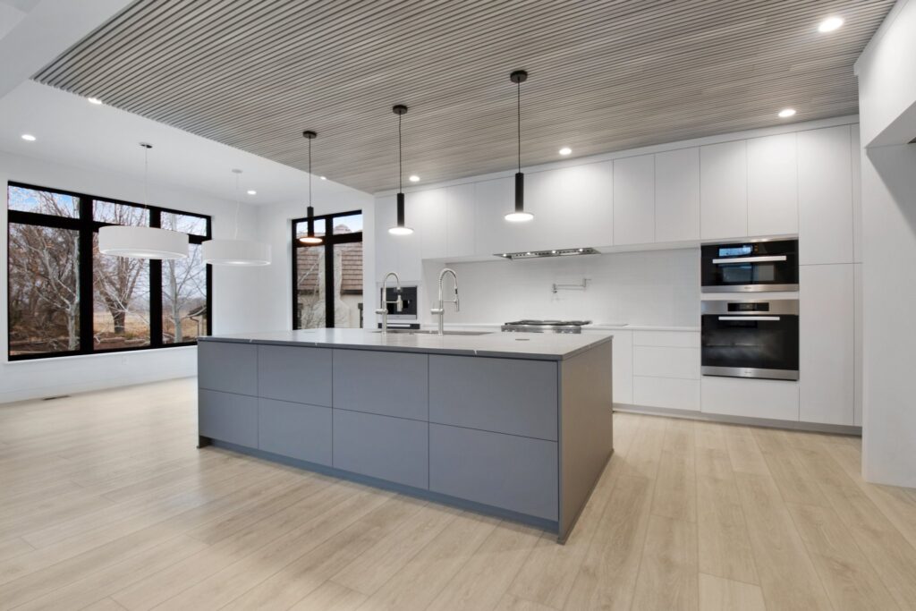 OPen concetp kitchen and dining room, contemporary modern style home, warm wood floor, gray island, flat panel cabinets, wood slat ceiling, Sherwin Williams Ice Cube walls, cabinets, ceiling, cool white