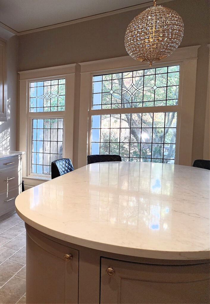 Oval kitchen island with rounded cornersm, taupe greige mushroom painted cabinets, off-white cream trim and greige wall paint color - Copy
