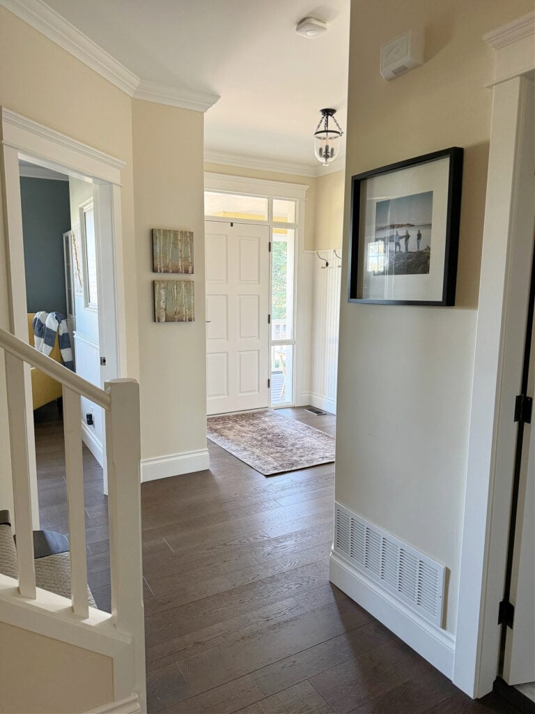 Sherwin Williams Antique White, Pure White trim, in natural light dark hallway and entryway, dark wood floor