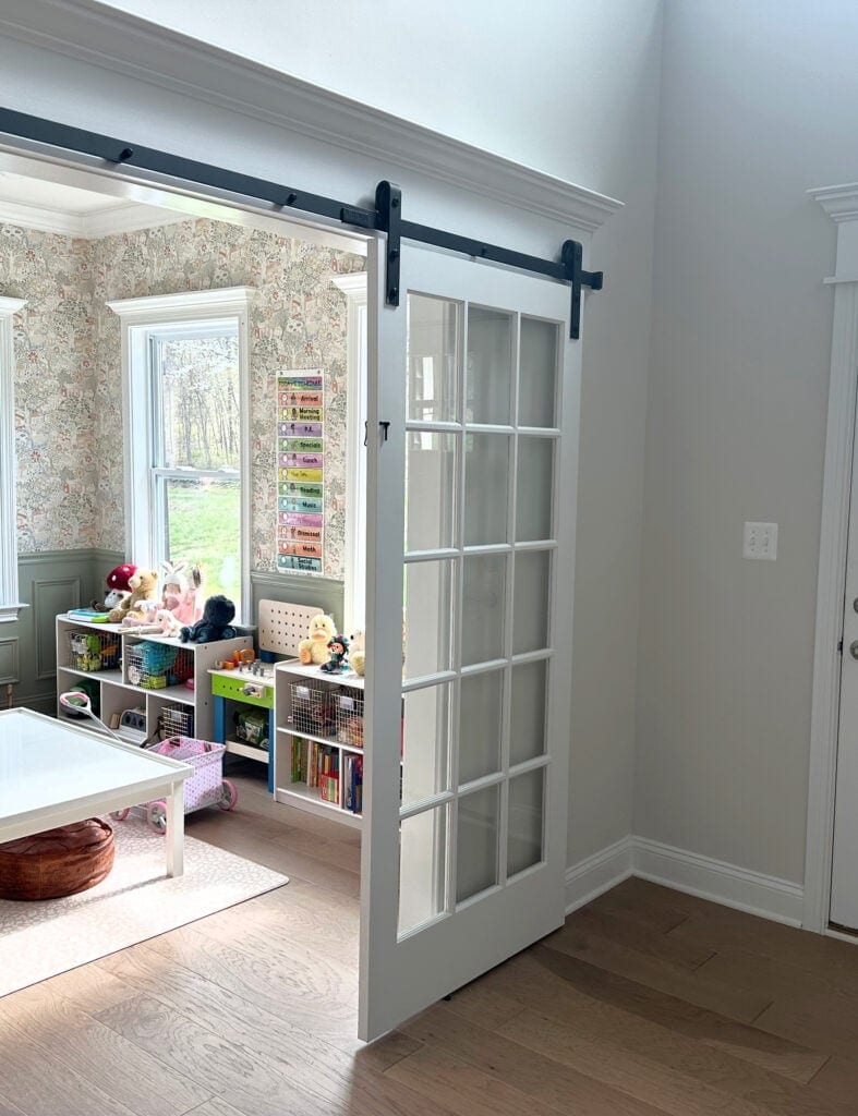 Sherwin Williams City Loft, warm gray off white in entryway, sliding doors to kids playroom with green gray wainscoting and floral wallpaper
