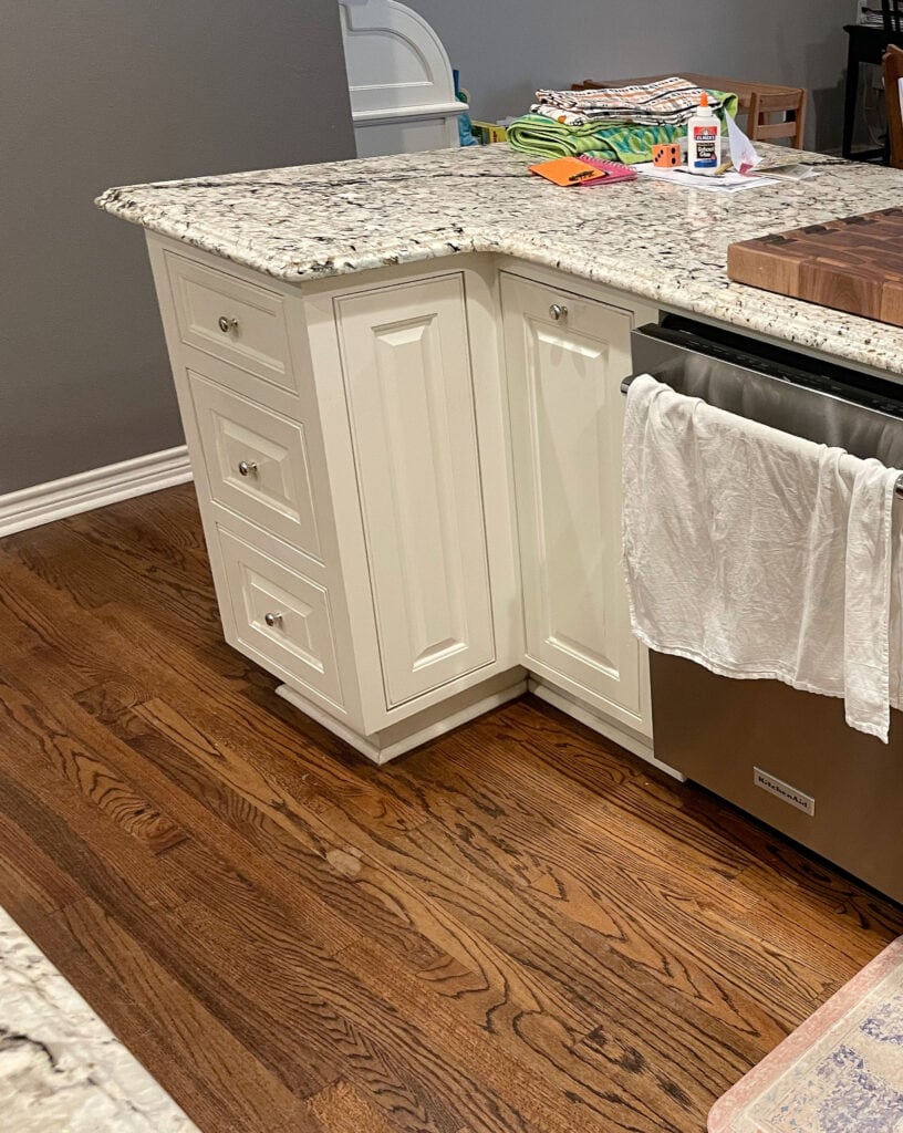 Sherwin Williams Dover White creamy white, cream paint color on painted kitchen cabinets, granite countertop, brown oak floor