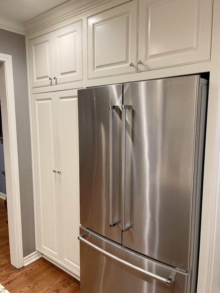 Sherwin Williams Dover White, warm creamy white cream cabinets with stainless steel, oak floor, violet gray paint color on walls