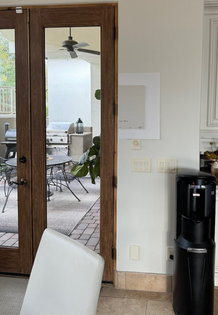 Sherwin Williams Egret White with warm off-white neutral, wood trim and travertine tile floor