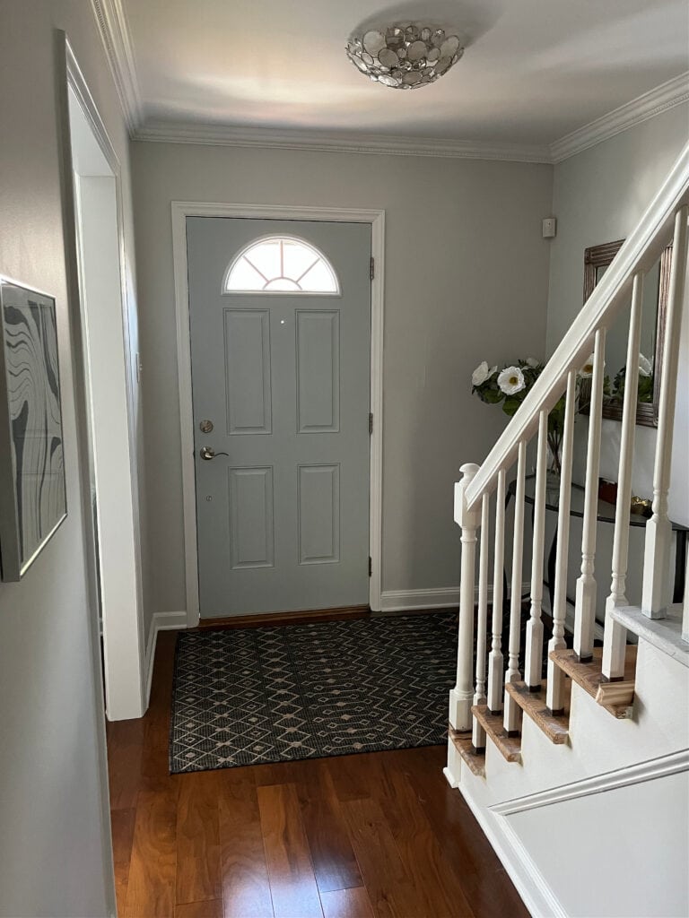 Sherwin Williams Fleur de Sel in dark entryway, off white gray with cool blue undertones, Wickham Gray front door, BEnjamin Moore Super White trim and stair railing