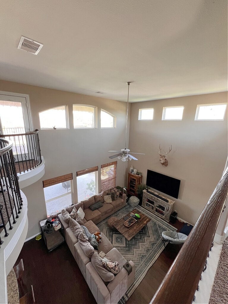 Sherwin Williams Kilim Beige, high ceilings, two story living room, dark wood floors, sectional, open railing