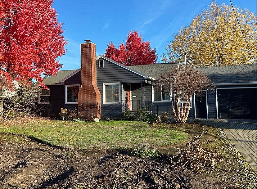 Sherwin Williams Peppercorn, painted exterior siding, dark gray, Tricorn Black garage door, red orange brick chimney, Alabaster warm white trim, white windows