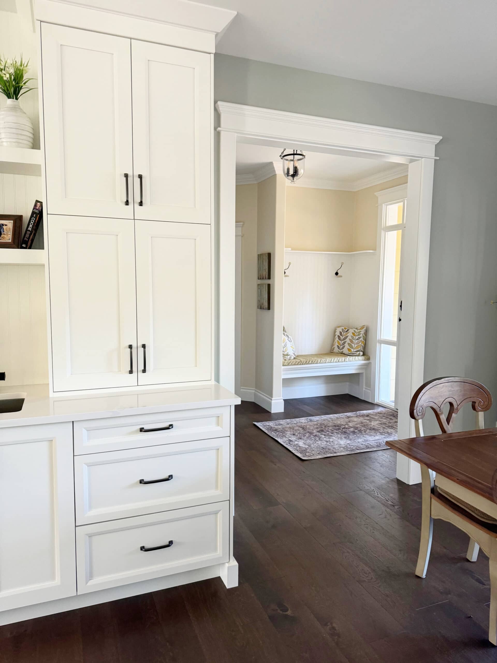 Sherwin Williams Pure White cabinets, Austere Gray paint color on walls with Antique White in entryway, dark wood floor, white quartz countertop