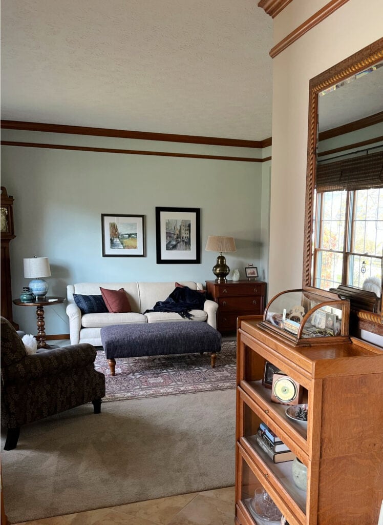 Sherwin Williams Sea Salt in living room, taupe beige carpet, Edgecomb Gray entryway, dark wood trim and crown molding. before photo