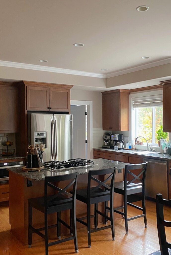 Sherwin Williams Simplify Beige, maple wood kitchen cabinets, Pure White trim, wood floor, dark granite, island