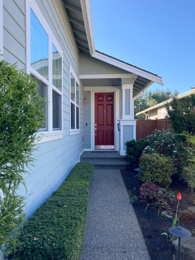 Sherwin Williams Unusual gray on painted hardi exterior horizontal siding, Alabaster warm white trim, white windows, red front door.