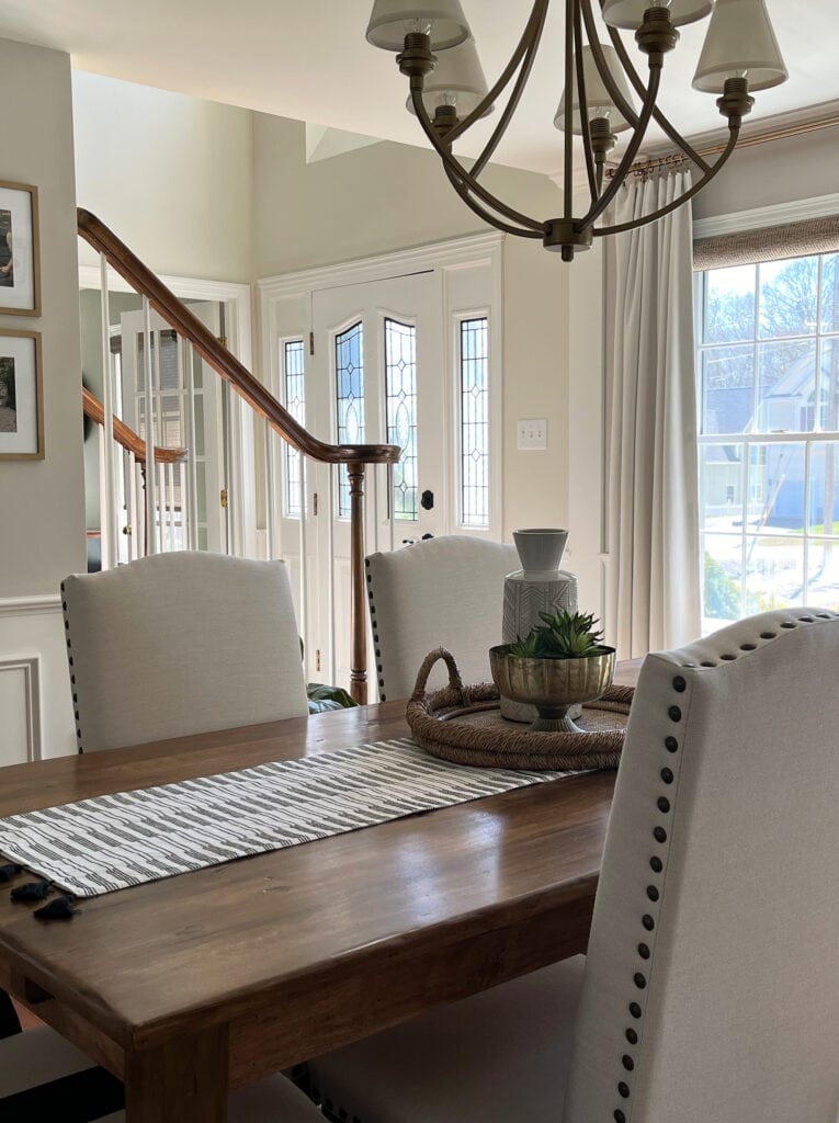 Sherwin Williams Worldly Gray greige in dining room, foyer entryway painted Benjamin Moore White Dove, oak stair railing, transitional furniture