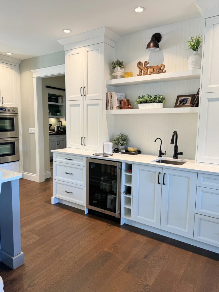 Sherwin Williams white cabinets, Cosentino Silestone Et Calacatta Gold white quartz countertop, dark wood floor, black hardware and sink faucet, Austere Gray walls