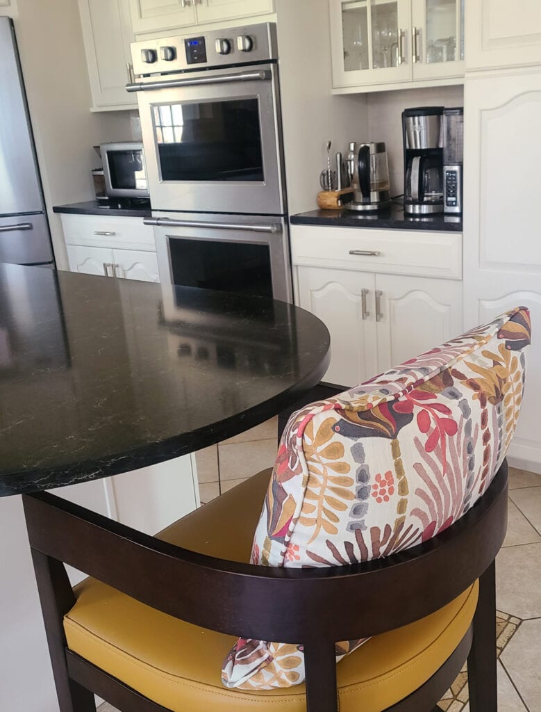 Wood cabinets, cathedral top, painted off-white beige, benjamin moore maritime white, beige travertine look tile floor, black granite countertop, stainless steel