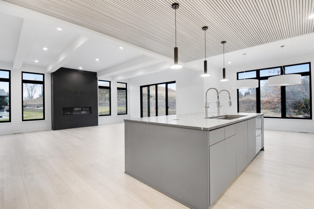 open concept modern, contemporary home, black fireplace, black windows, warm wood floor, gray island, Sherwin Williams Ice Cube cool white gray on walls.