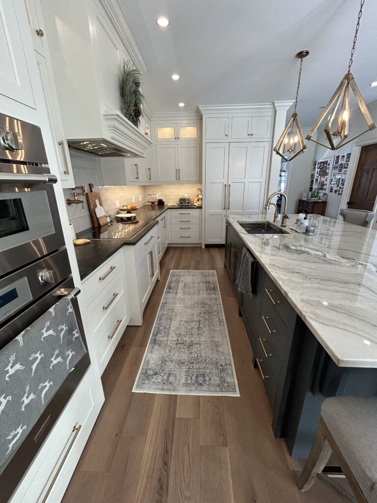 Quartzite countertop, wood floor, kitchen cabinets Sherwin Williams Pearly White, French Beret, navy blue island