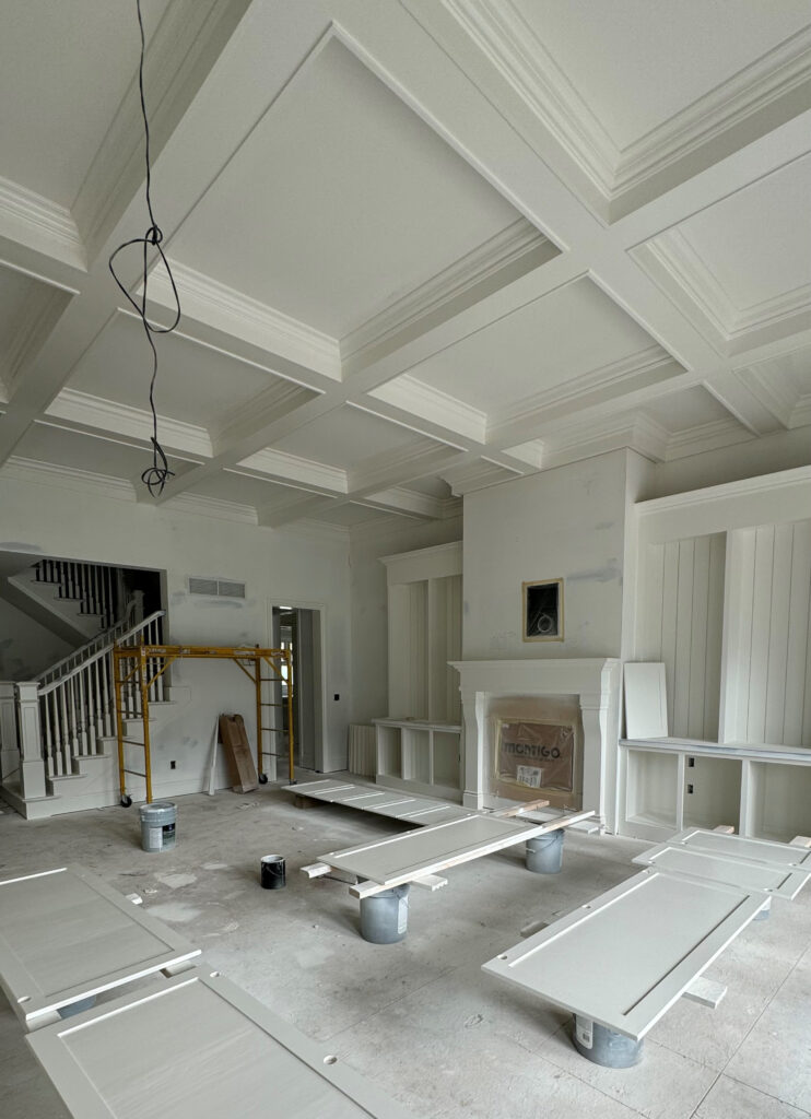 Sherwin Williams Alabaster, living room with coffered ceiling, moldings, trims, and built-in cabinets, fireplace surround, warm white paint color