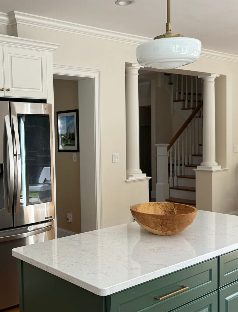 Sherwin Williams Pearly White off white on walls, Benjamin MOore White Dove cabinets, soft white quartz countertop, Peale Green painted kitchen island
