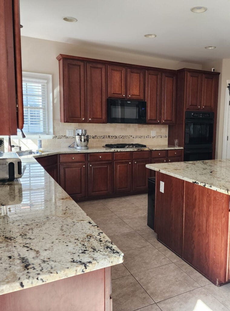 large kitchen with red cherry stained wood cabinets, travertine tile backsplash, beige tile floor, beige, cream, taupe granite countertops, large island, update ideas, black appliances (1)