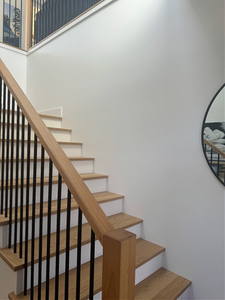 white oak stairs, white risers, Benjamin Moore White Dove walls, hemlcok stair railing, black metal spindles, staircase at lake home