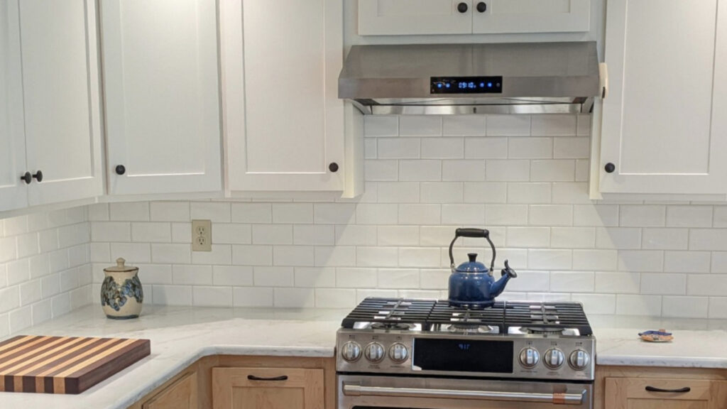 Sherwin Williams Alabaster in kitchen with white subway tile, off-white quartz countertop, maple natural finish wood lower cabinets, stainless steel